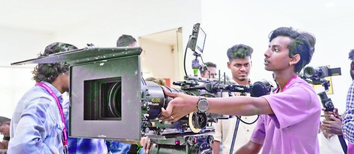Students operating a cinema camera on set